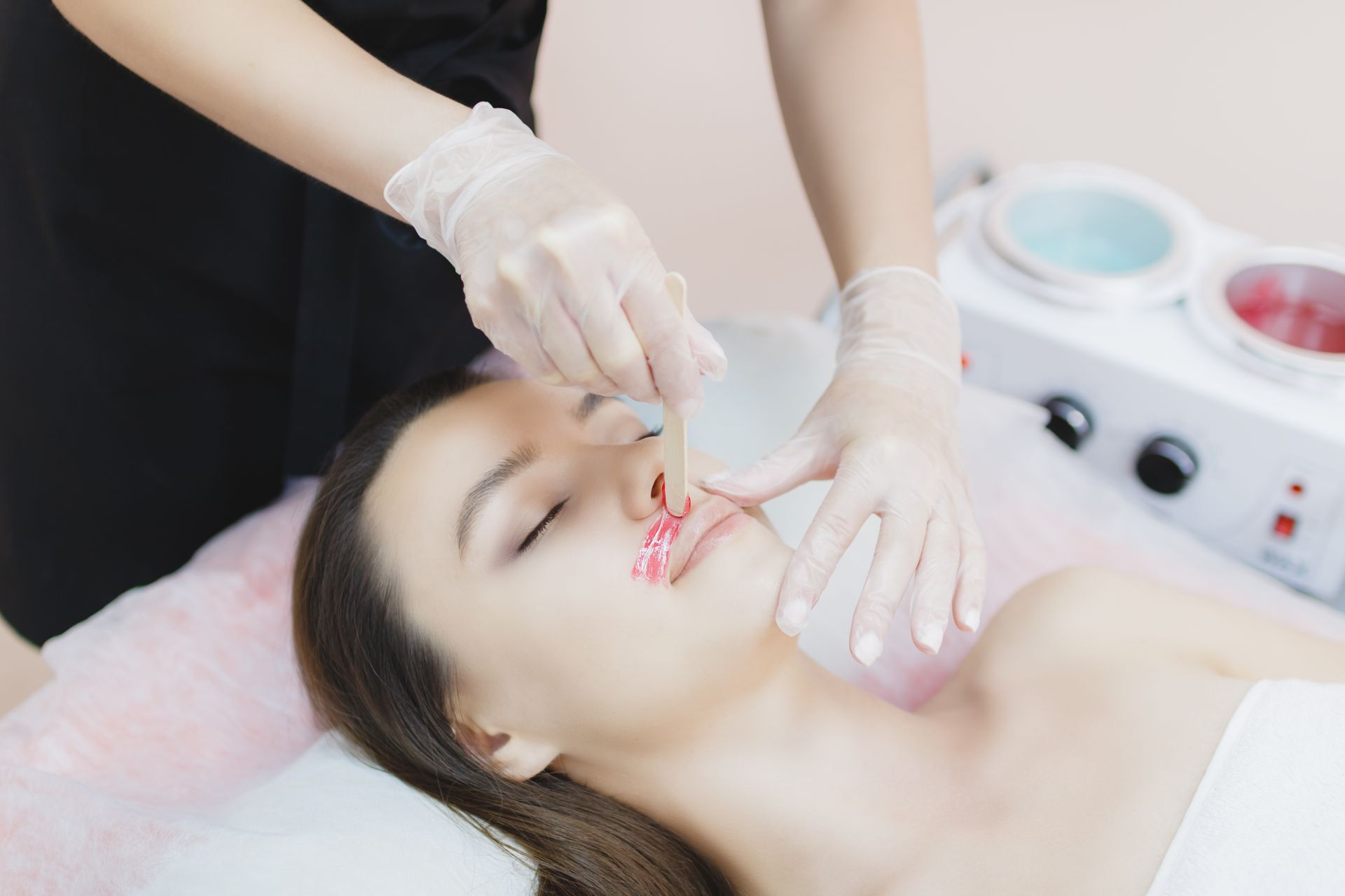 A woman is getting her lips waxed in a beauty salon.