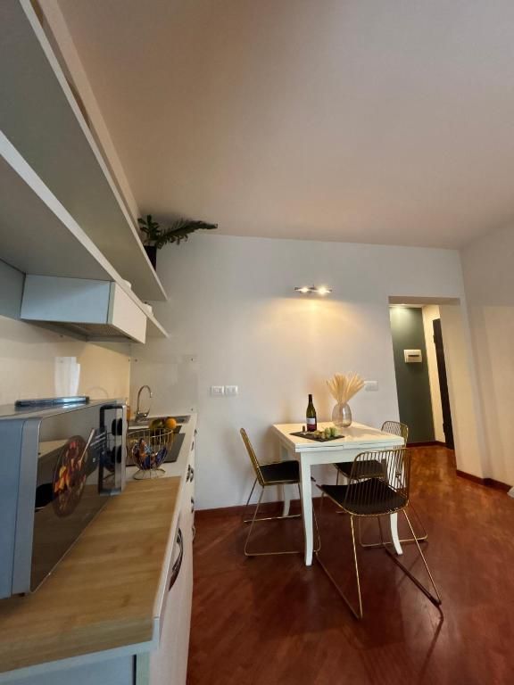 Piccola cucina e sala da pranzo con pareti bianche, pavimenti in legno e mobili minimalisti.