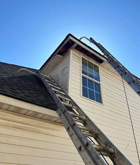 A ladder is attached to the roof of a house.