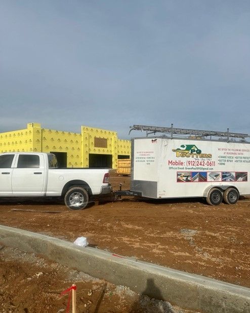 A white truck is towing a trailer in a dirt field.