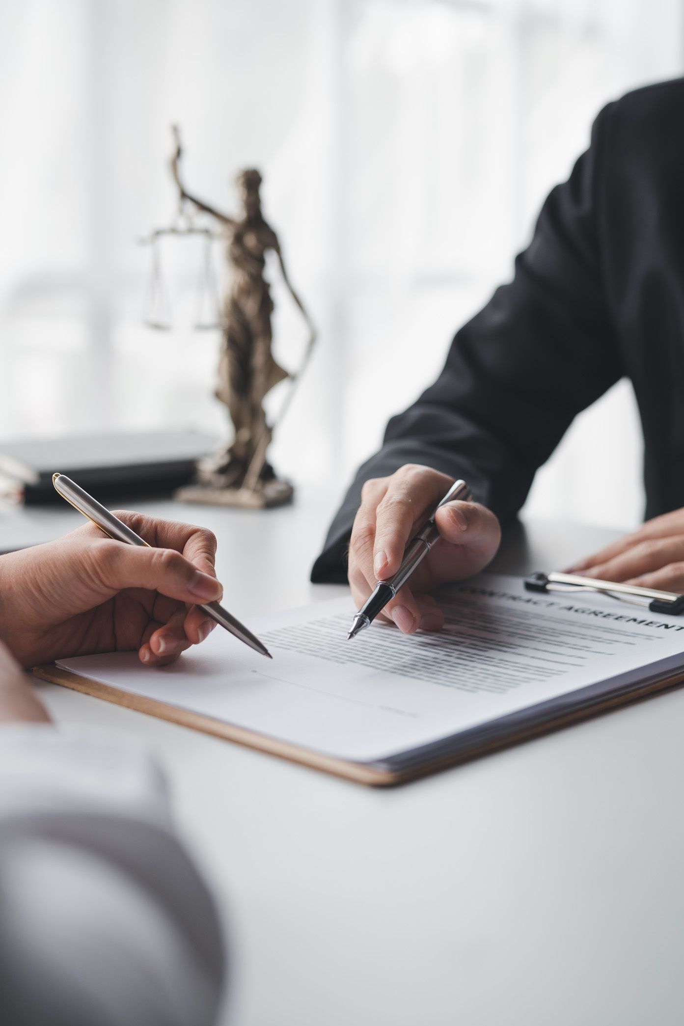 A man and a woman are sitting at a table writing on a clipboard.