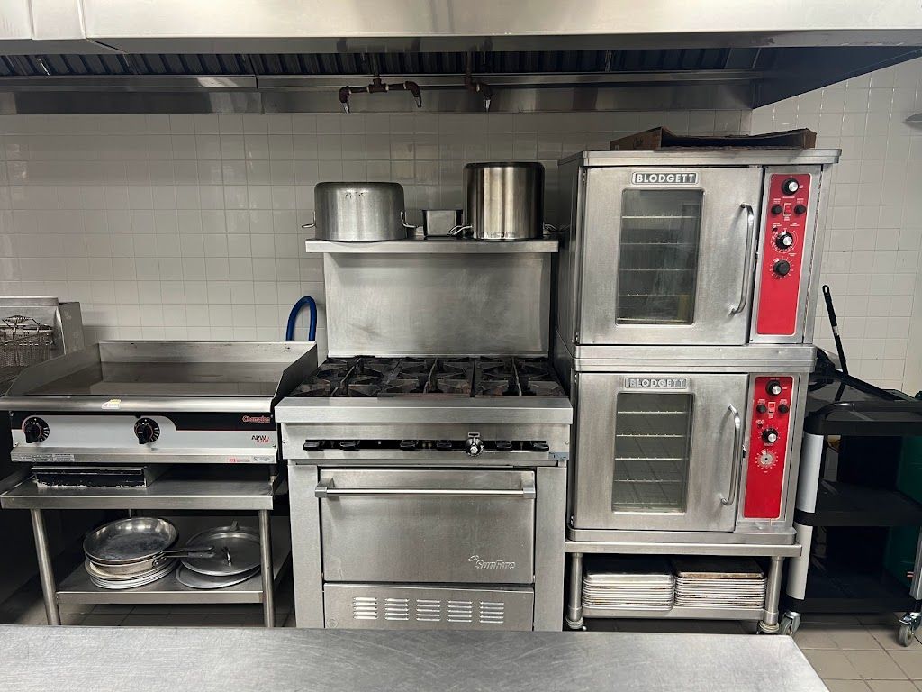 A kitchen with stainless steel appliances including a stove and oven
