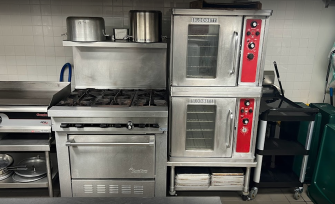 A kitchen with a stove , oven , and other appliances.