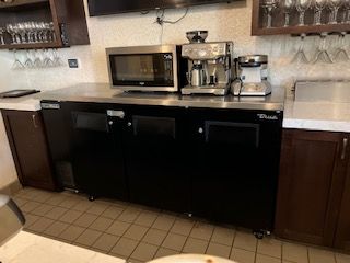 A kitchen with a microwave , coffee maker , and refrigerator.