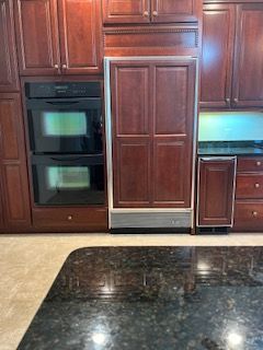 A Subzero Built-In Refrigerator with wood panels serviced and repaired by John's Heating, Cooling, and Appliance Repair.