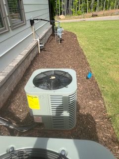 An air conditioner is sitting on the side of a house.
