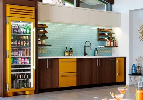 A kitchen with yellow cabinets and a yellow refrigerator.