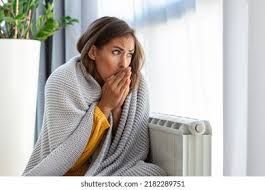 Women in a cold house because her furnace is not working to heat her home