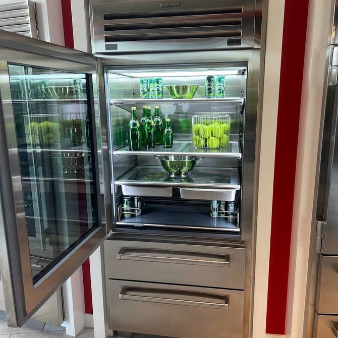 A stainless steel refrigerator filled with bottles and bowls