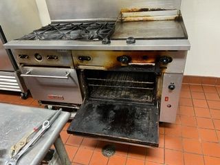 A stove with the door open in a kitchen.