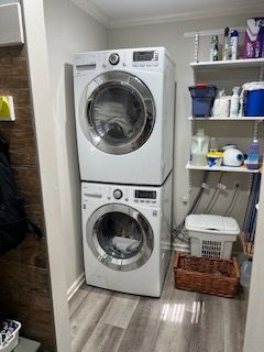 A washer and dryer in Griggin Ga repaired by John's Heating, Cooling, and Appliance Repair, are stacked on top of each other in a laundry room.