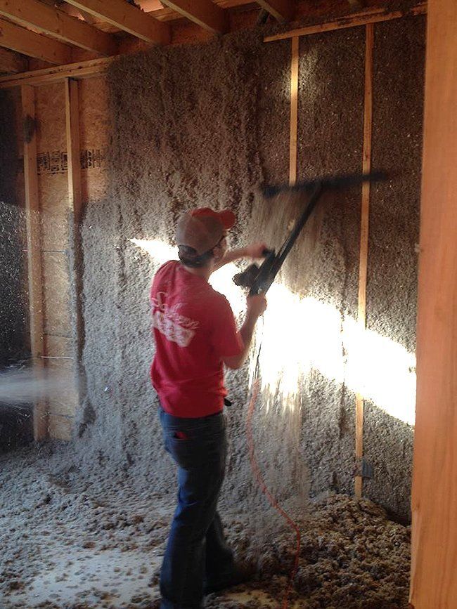 Worker Installing Cellulose Insulation on Wall — Hot Springs, AR — Southern Insulation & Gutters Inc