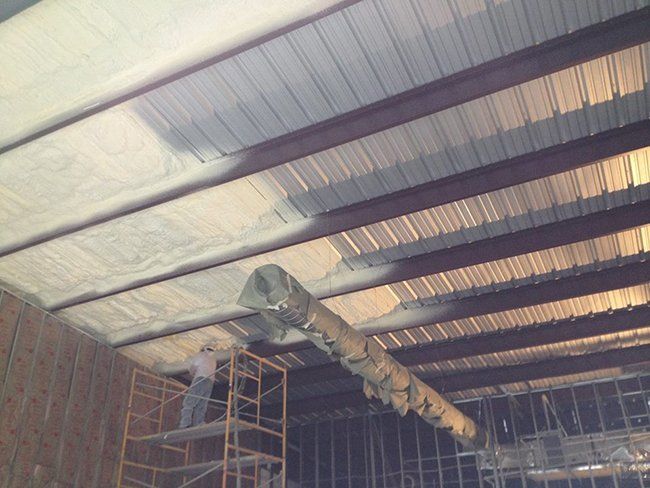 Worker Installing Foam Insulation on Ceiling — Hot Springs, AR — Southern Insulation & Gutters Inc