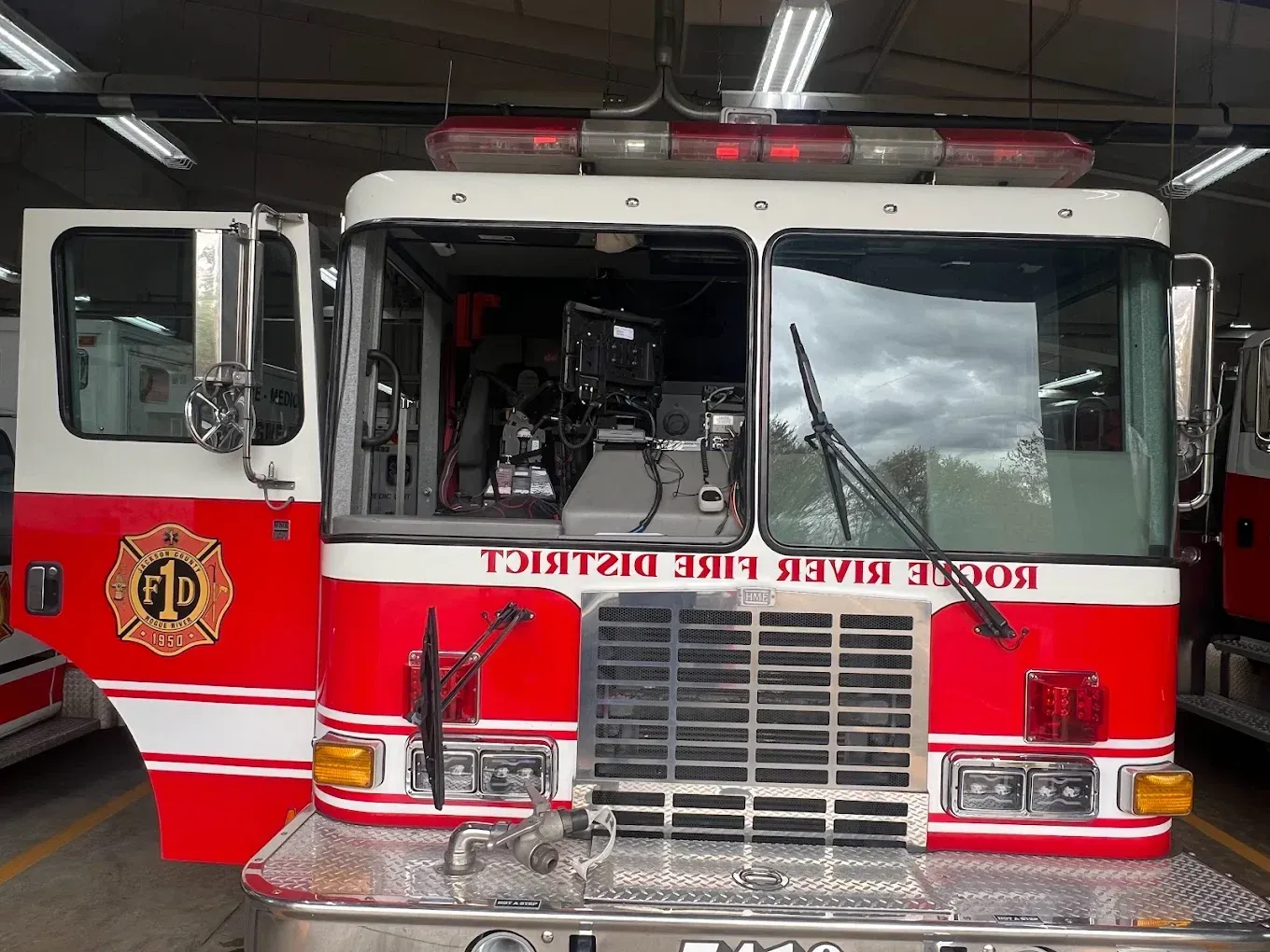 Fire truck, red and white, parked in a bay;