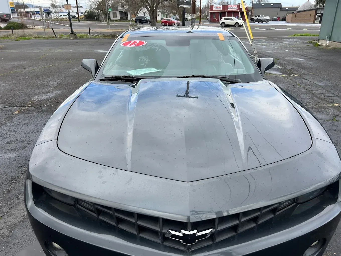 Gray Chevrolet Camaro parked outdoors with a for sale sticker on the windshield.