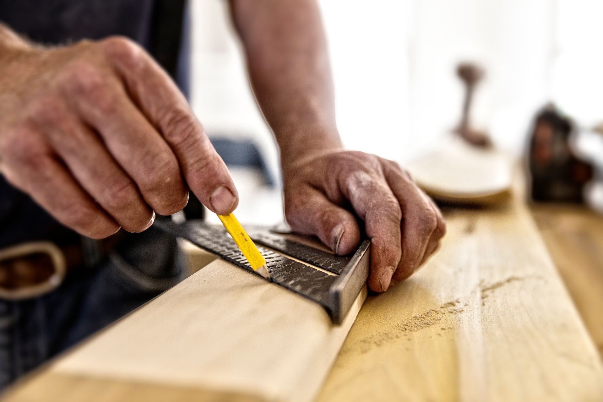 A man is using a ruler to measure a piece of wood.