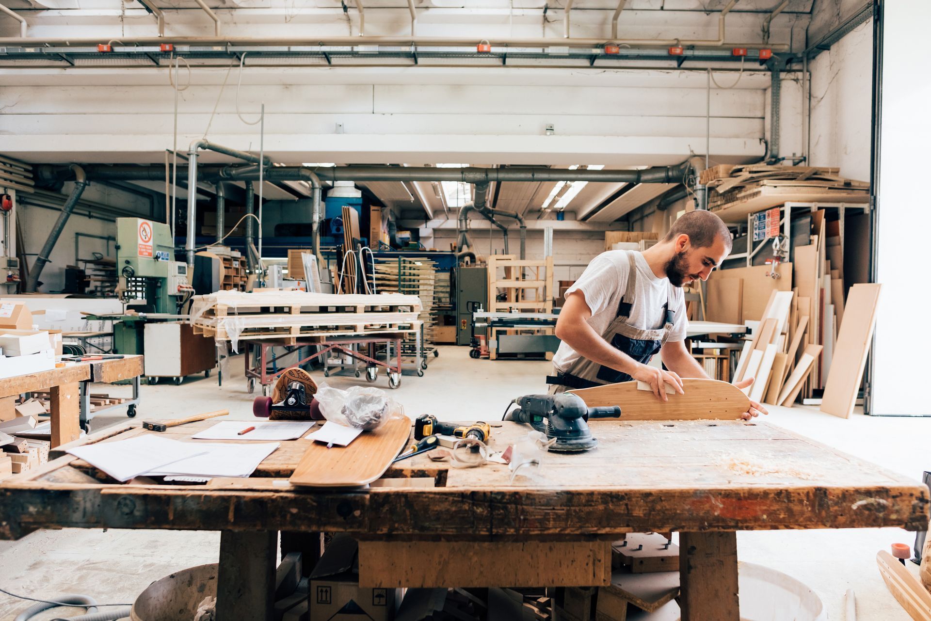 A man is working on a piece of wood in a workshop.