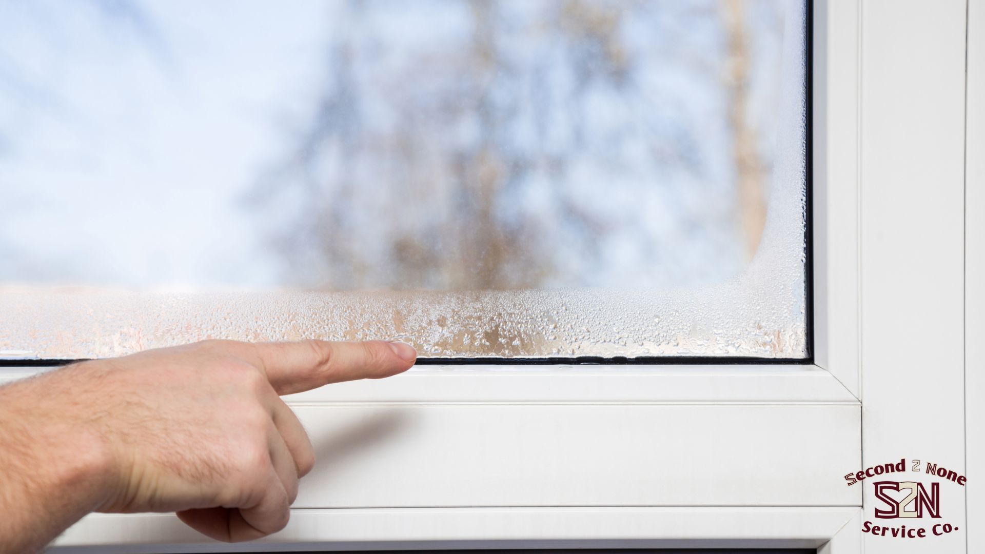 A person is pointing at a window with condensation on it in Columbus ga