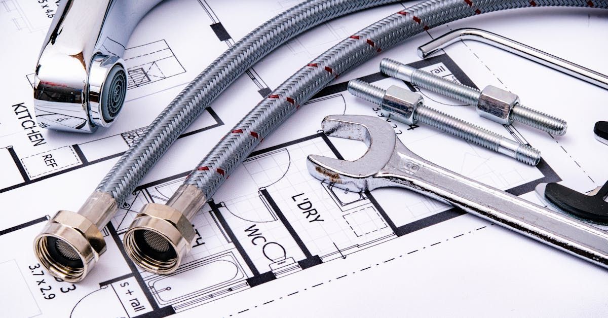 Plumbing components, including flexible hoses, a wrench, and fasteners, are arranged on top of a house blueprint.