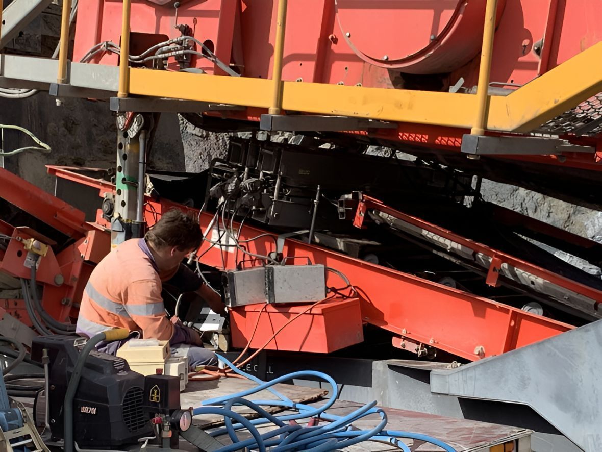 A Man Is Working On A Machine In A Factory — Belt Maintenance & Supplies Pty Ltd In Nindaroo, QLD