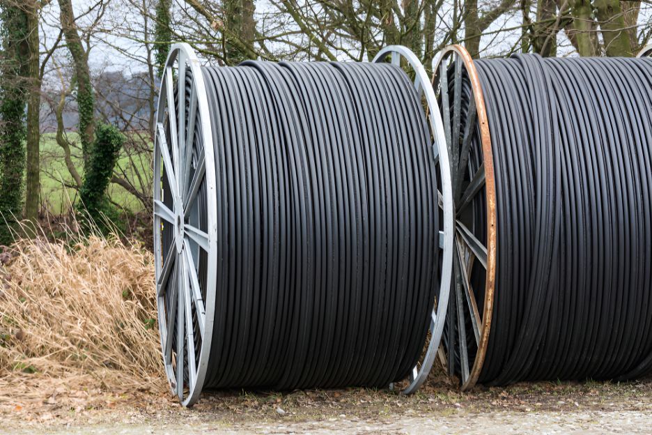 Three Spools Of Cable Are Stacked On Top Of Each Other In A Field — Belt Maintenance & Supplies Pty Ltd In Nindaroo, QLD