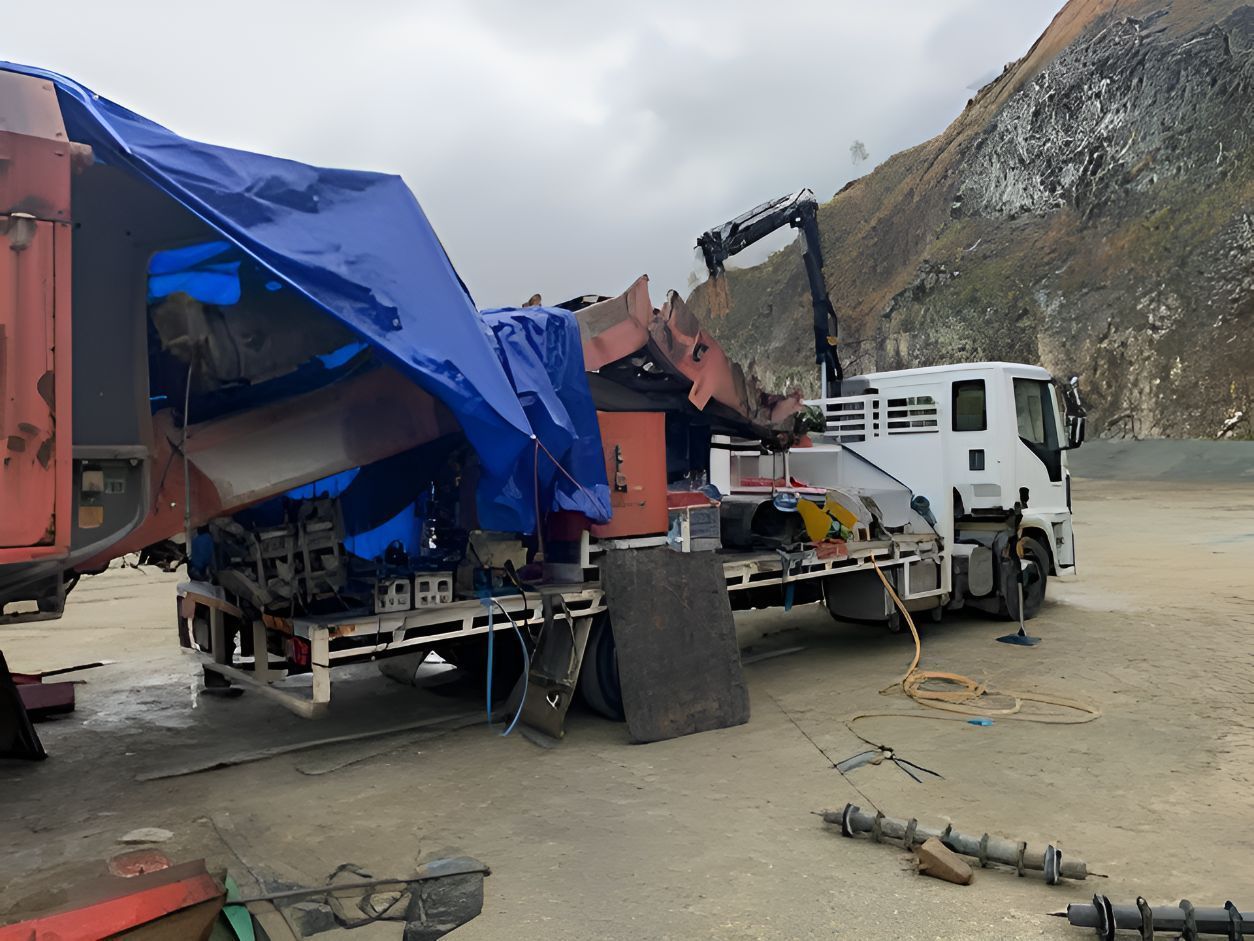 A Truck With A Blue Tarp On Top Of It Is Being Towed By A Crane — Belt Maintenance & Supplies Pty Ltd In Nindaroo, QLD