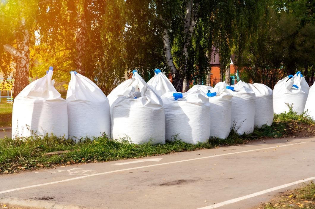A Row Of White Bags Sitting On The Side Of A Road — Belt Maintenance & Supplies Pty Ltd In Nindaroo, QLD