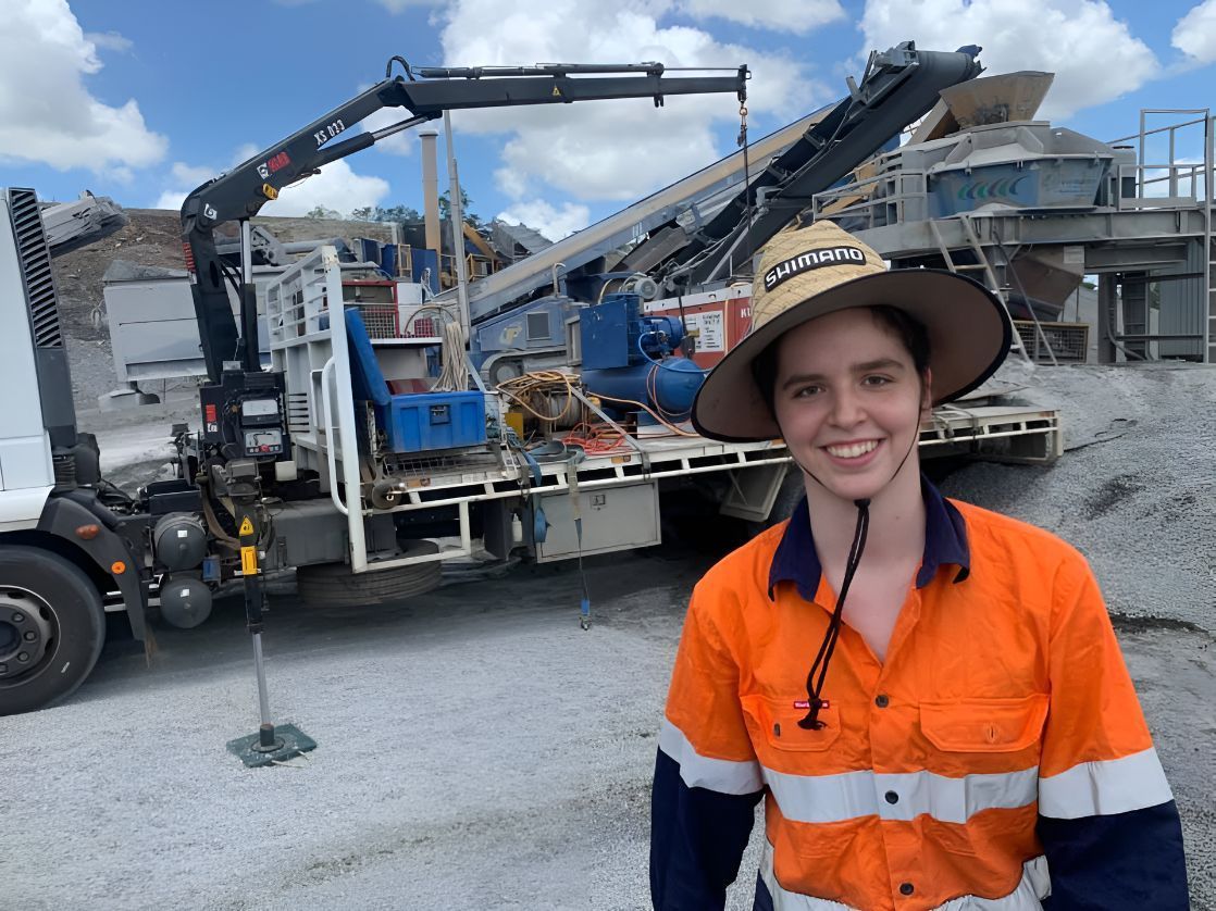 A Woman Wearing An Orange Shirt And A Hat In Front Of A Truck — Belt Maintenance & Supplies Pty Ltd In Nindaroo, QLD