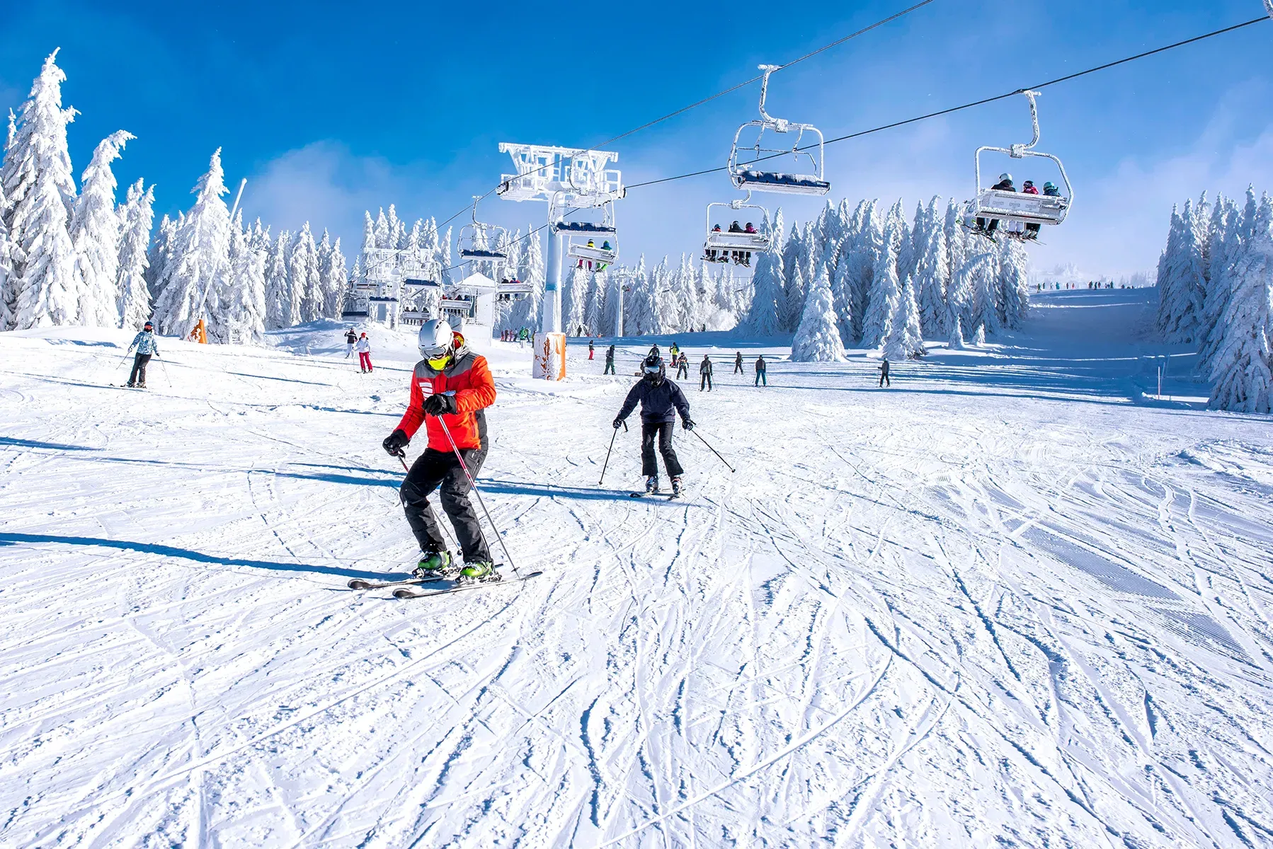 A group of people are skiing down a snow covered slope.