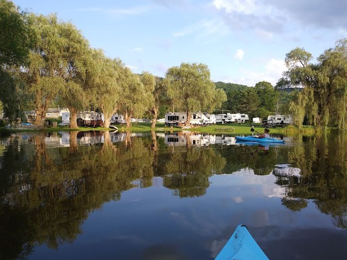 A blue kayak is floating on a lake with trees in the background