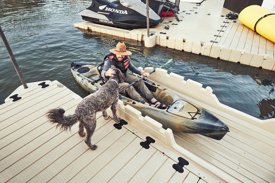 man getting ready to set out on canoe and petting his dog