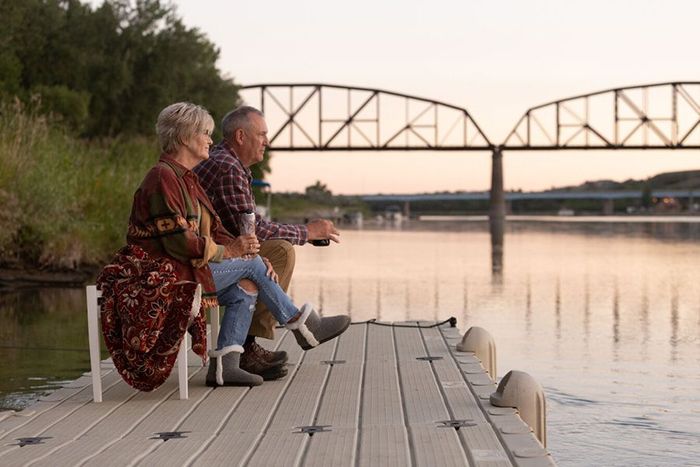 middle-aged couple enjoying sunset view on their boat dock