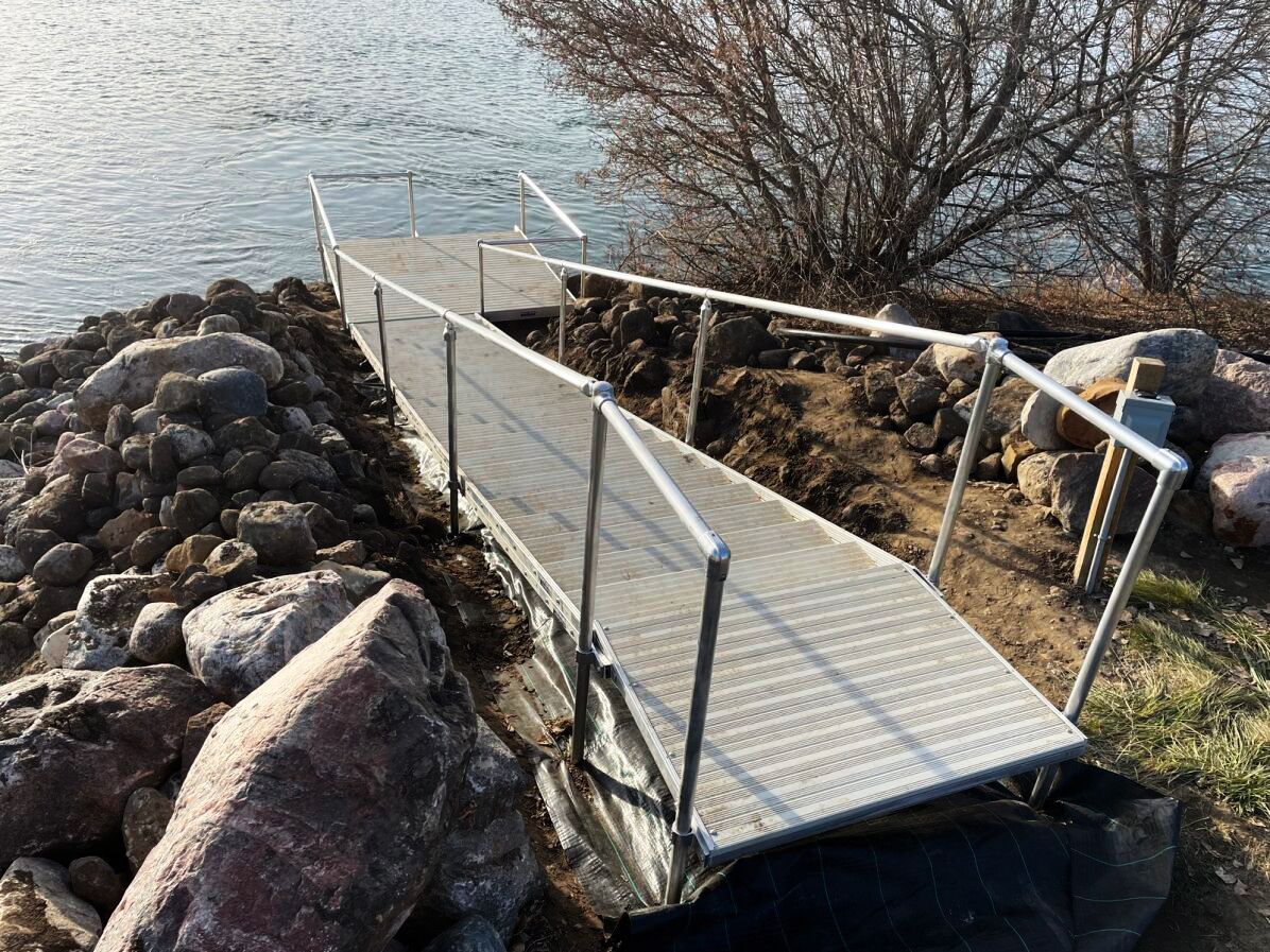 a metal walkway leading to a body of water .