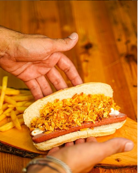 Piatto bianco con involtino di cavolo verde e salsa verde chiaro.