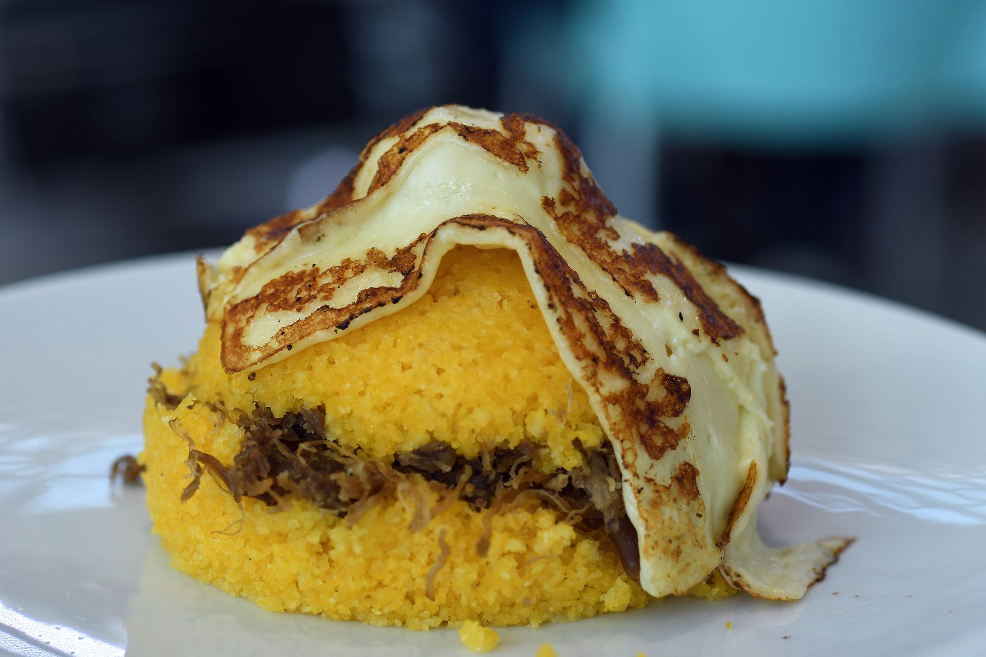 Panino con lattuga, birra e salse su un tagliere di legno.