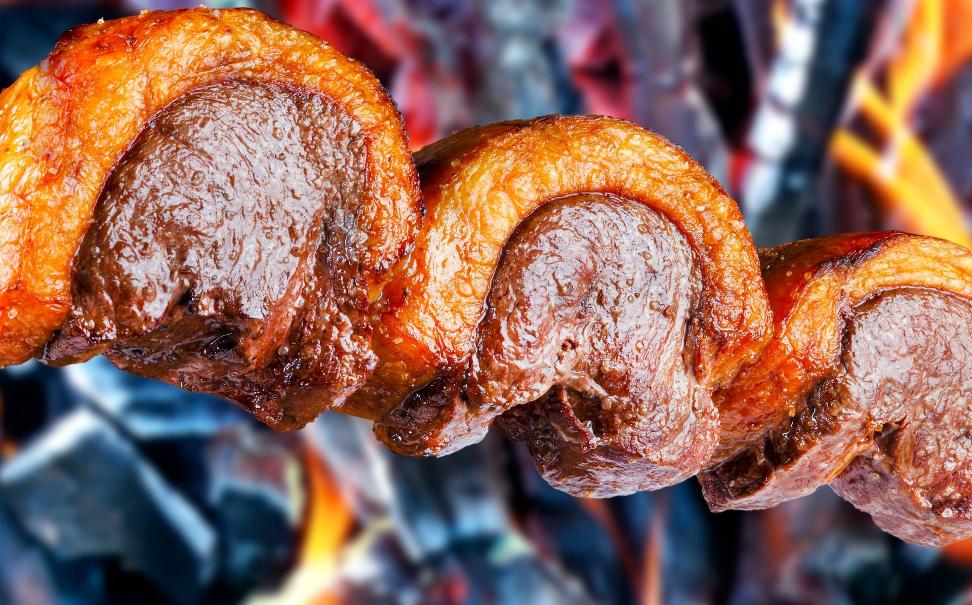 Apparecchiatura del tavolo del ristorante per due con sedie color verde acqua e parete blu scuro con fiori rossi.