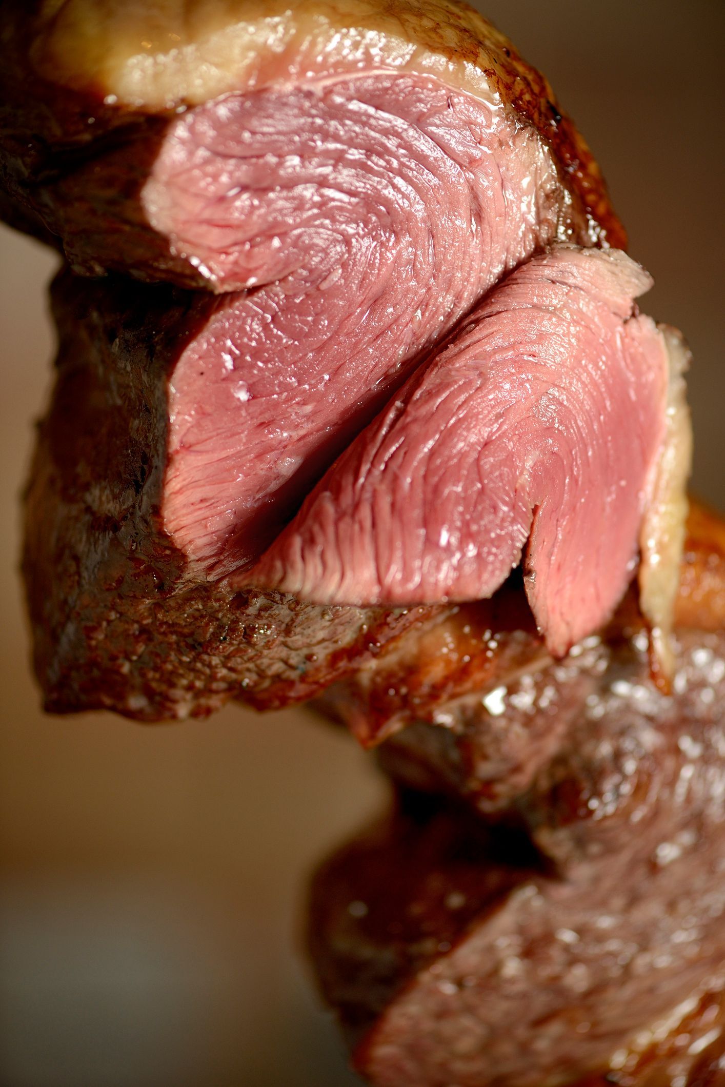 Persona che tiene in mano un grande panino tagliato a metà; sono visibili pollo, formaggio e lattuga.