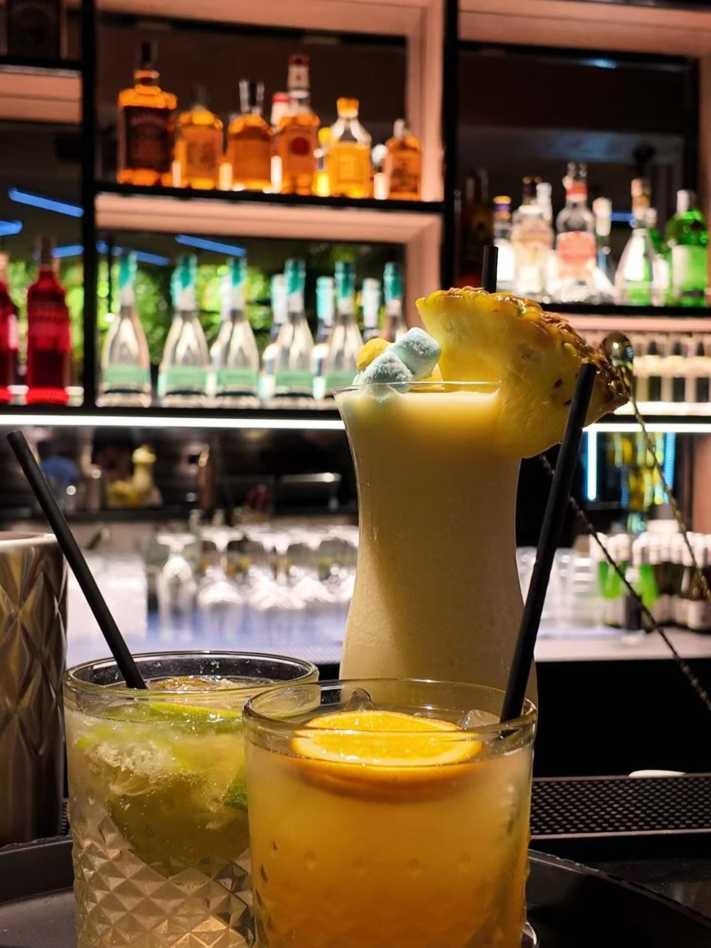 Panino con lattuga, birra e salse su un tagliere di legno.