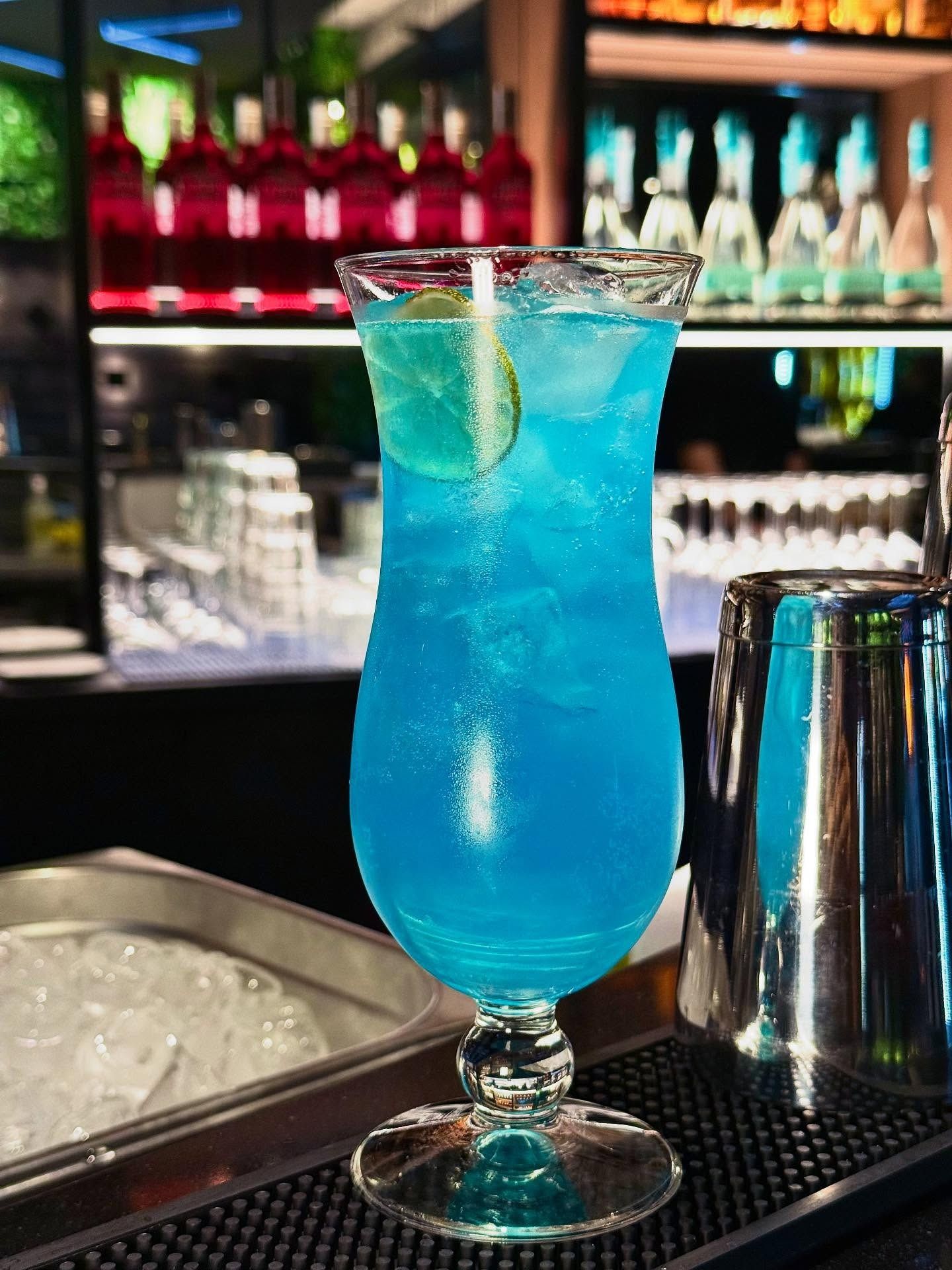 Persona che tiene in mano un grande panino tagliato a metà; sono visibili pollo, formaggio e lattuga.