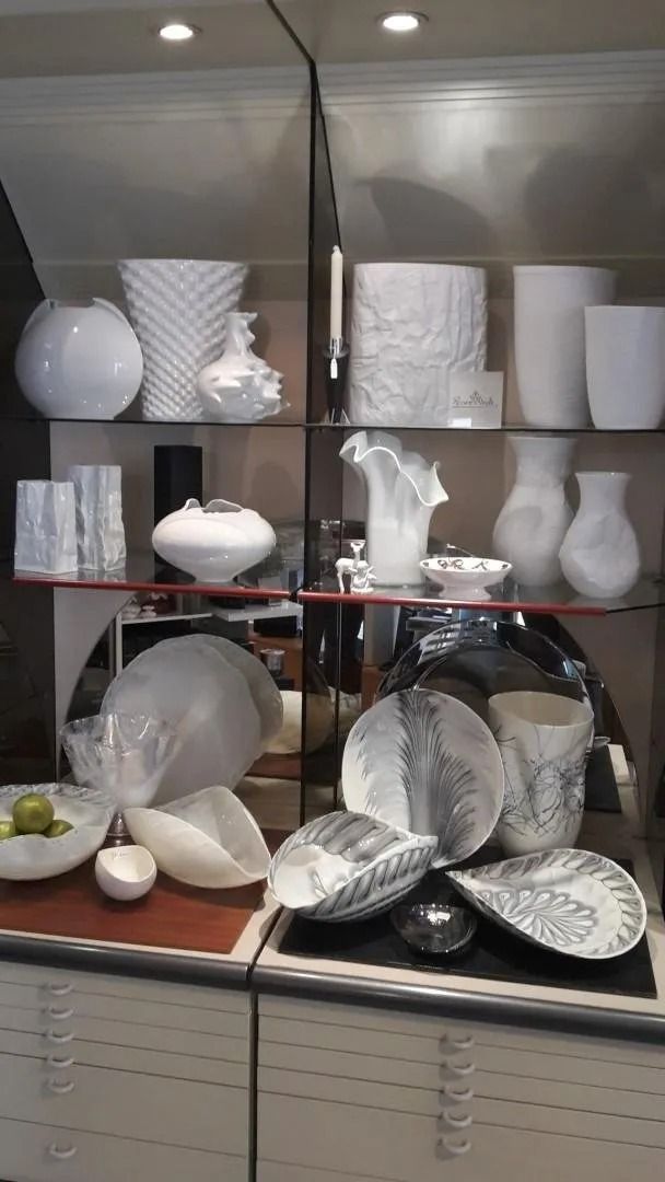 Una vetrina piena di vasi e ciotole bianchi