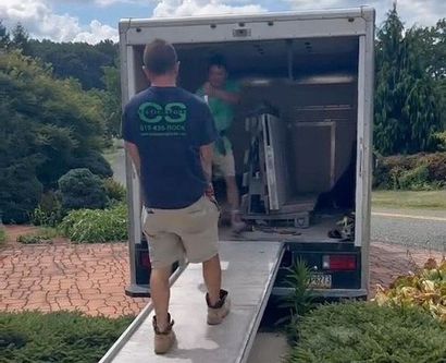 A man wearing a cs shirt is walking towards a truck