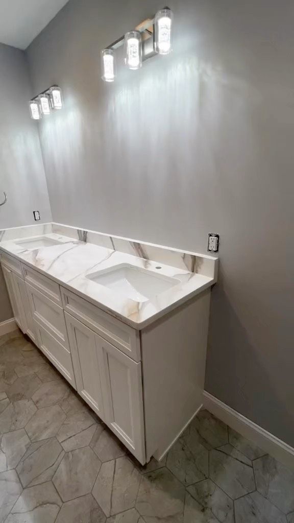 A bathroom with two sinks and a light fixture.