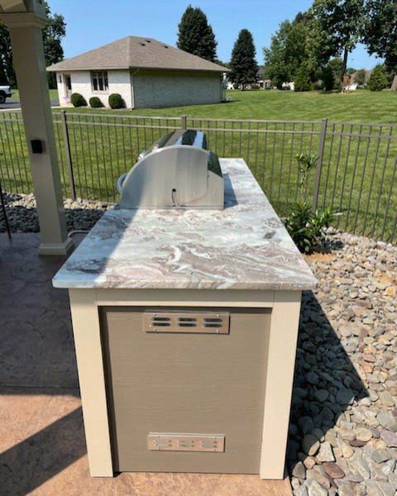 A kitchen island with a stainless steel grill on top of it.