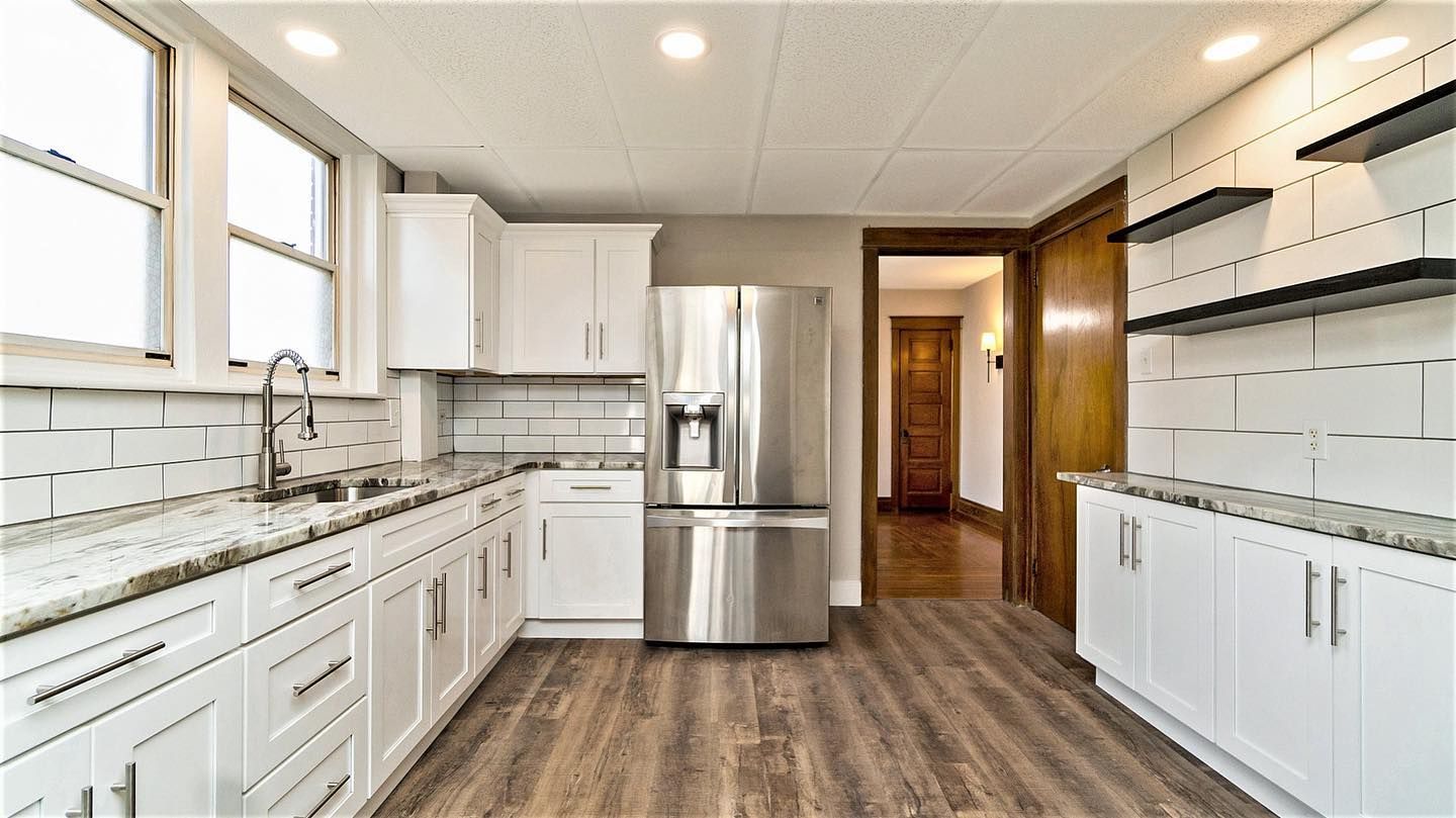 A kitchen with white cabinets and stainless steel appliances.