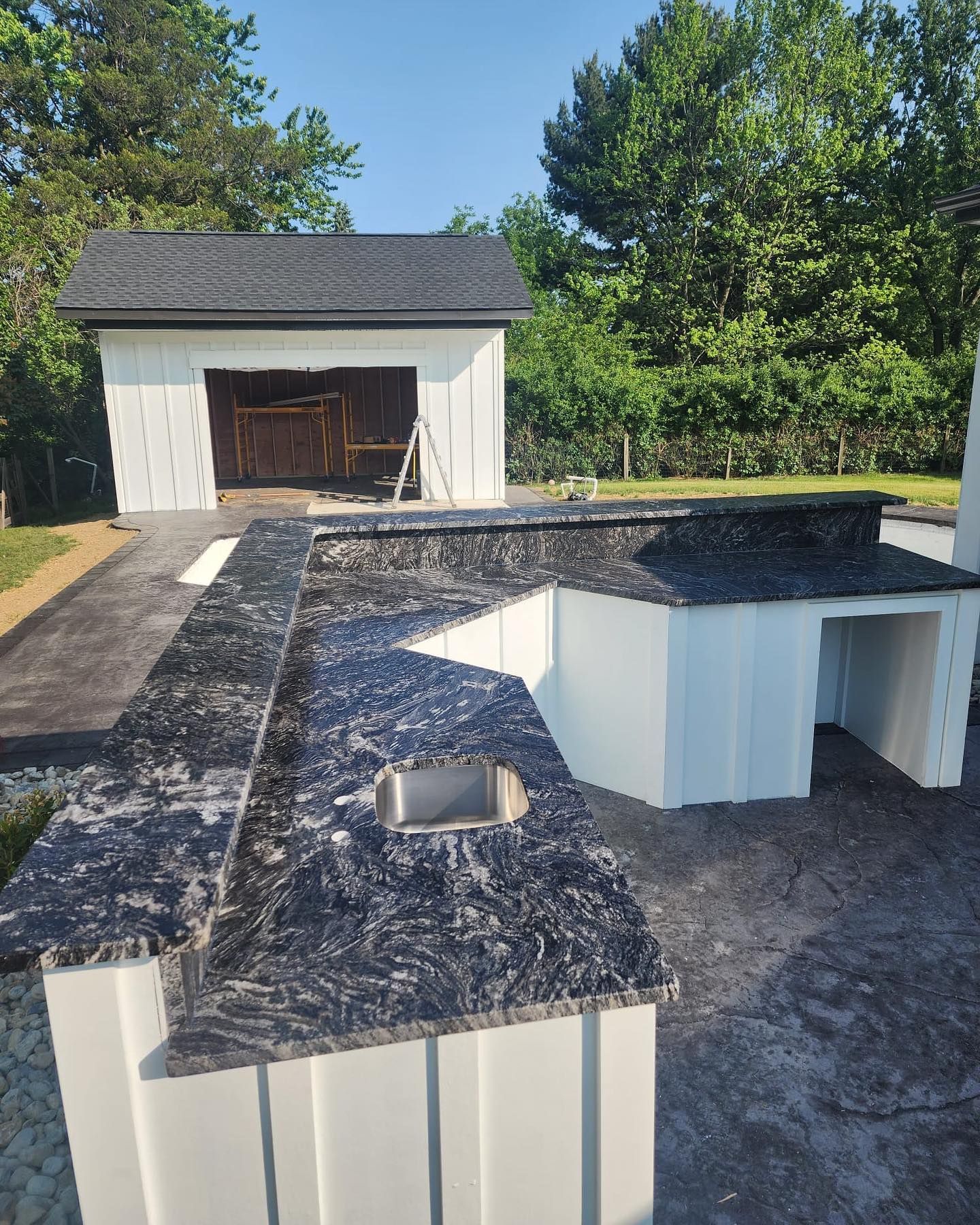 A kitchen with granite counter tops and a sink in front of a garage.