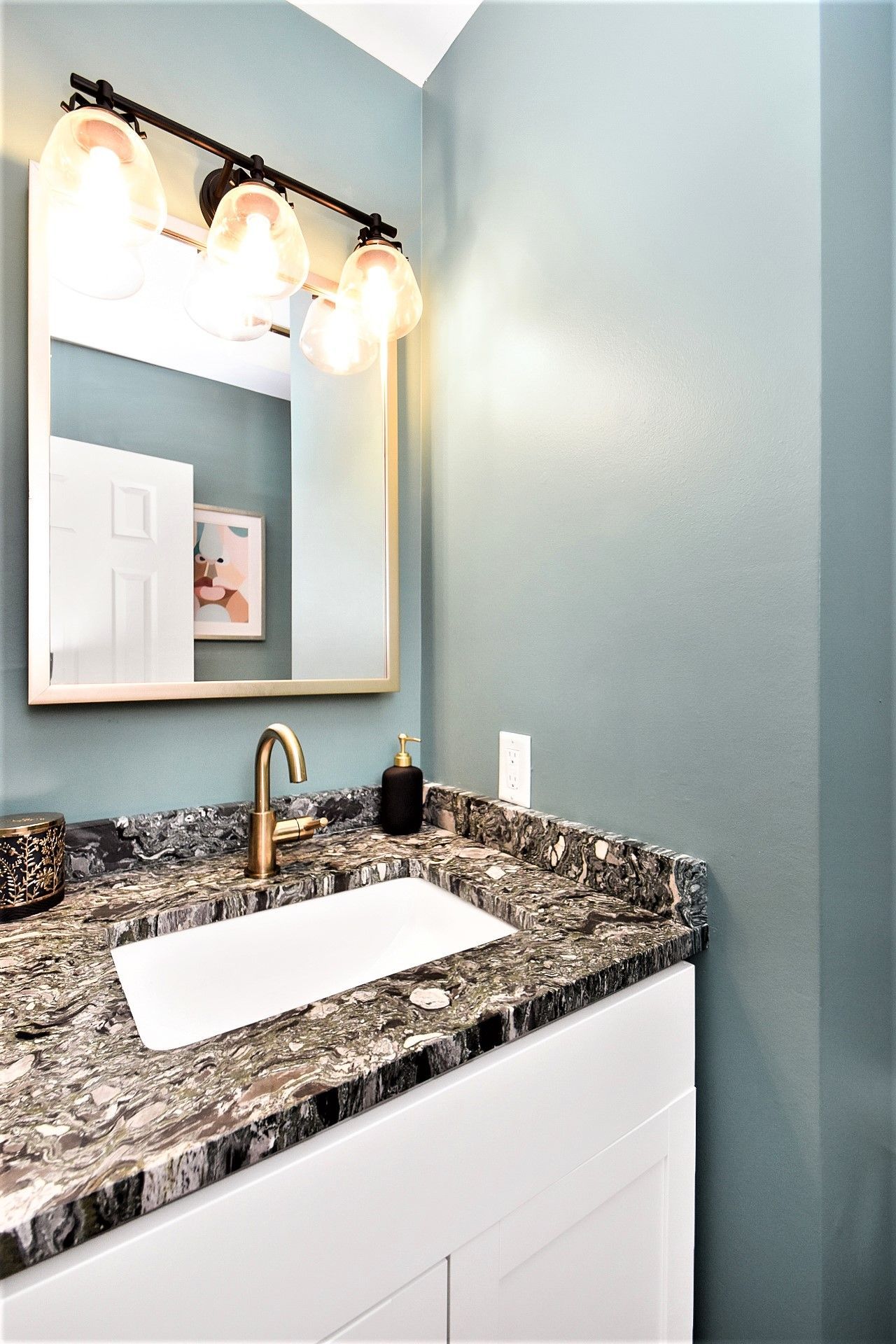A bathroom with a sink and a mirror on the wall.