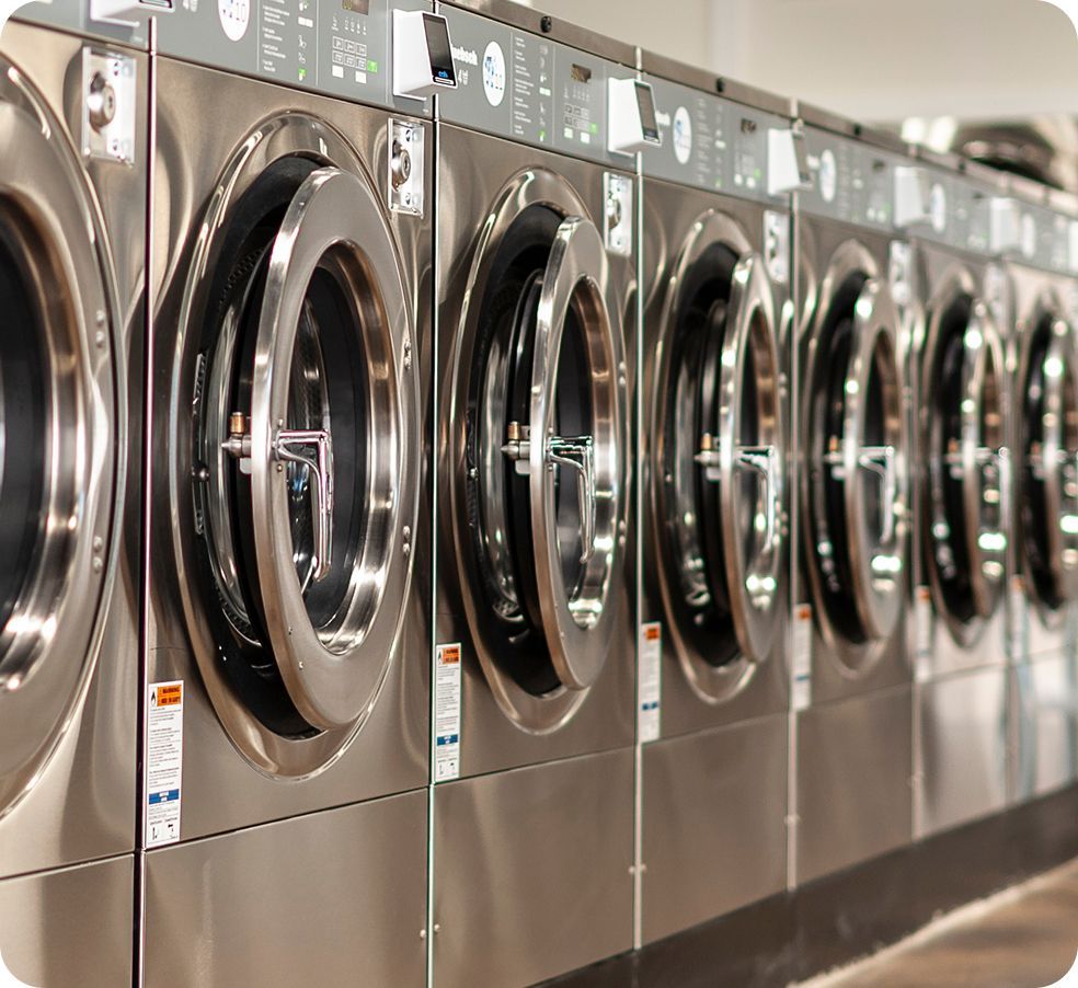 Stack of folded laundry, Tide detergent, and a laundromat sign. Fresh Suds Laundromat Memphis TN.