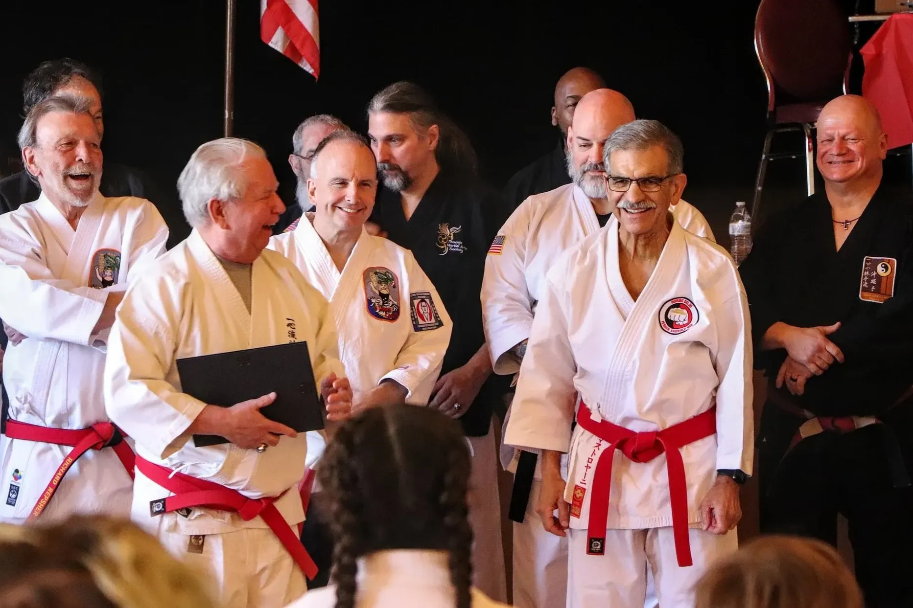 A group of men in karate uniforms with red belts