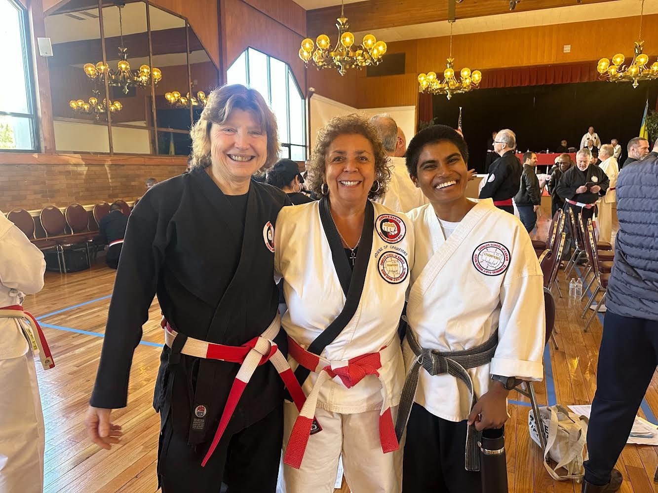 Three women are posing for a picture together in a gym.