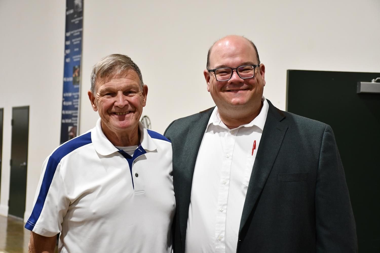 Two men are posing for a picture together in a room.